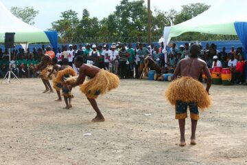 A picture containing African traditional dancers dancing to indicate the love of their culture.